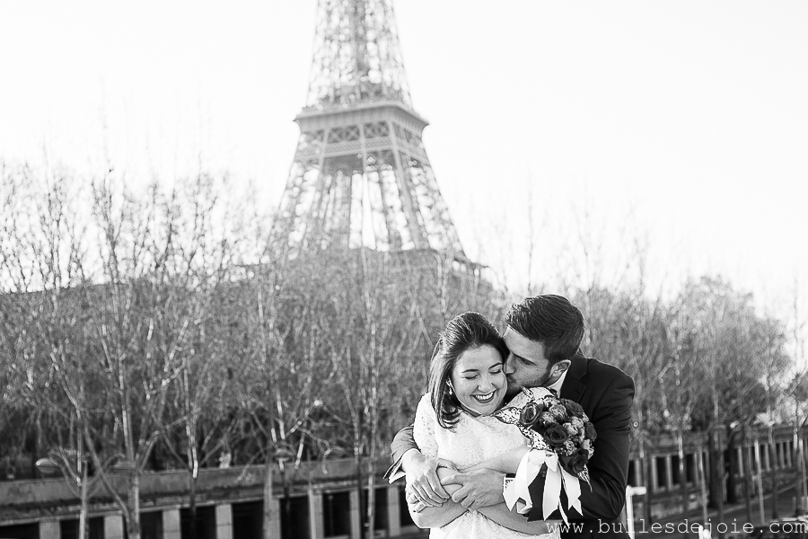 Homme enlaçant sa femme devant la Tour Eiffel | Bulles de Joie Photographie, photographe de gens joyeux