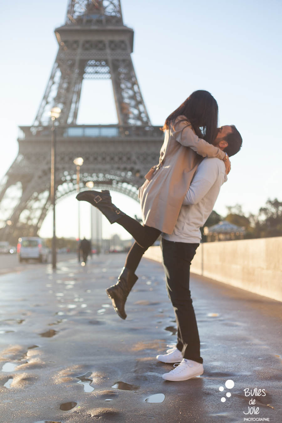 shooting photo couple : jeune homme soulevant sa femme, au pied de la Tour Eiffel