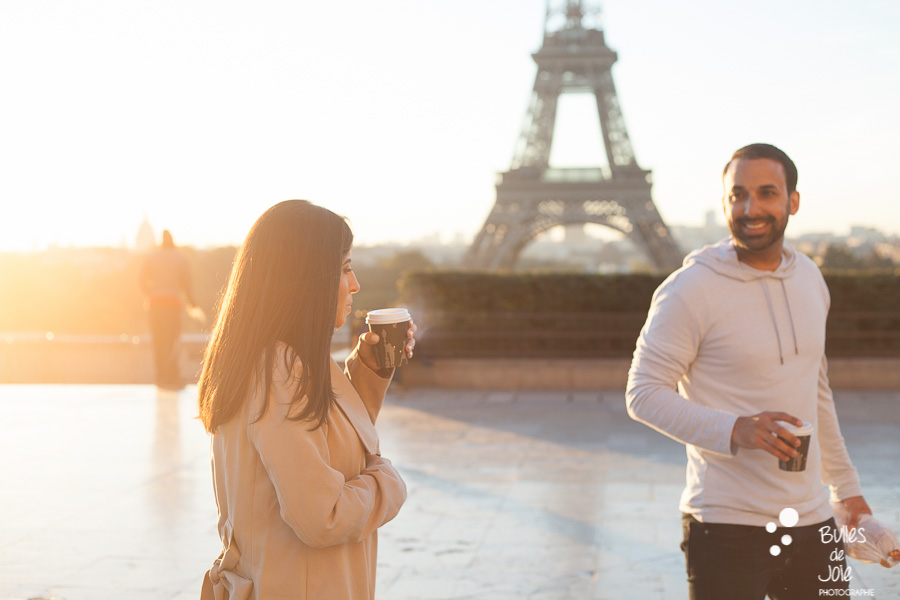 Jeune femme soufflant sur son café fumant en regardant son mari, sur le parvis du Trocadéro