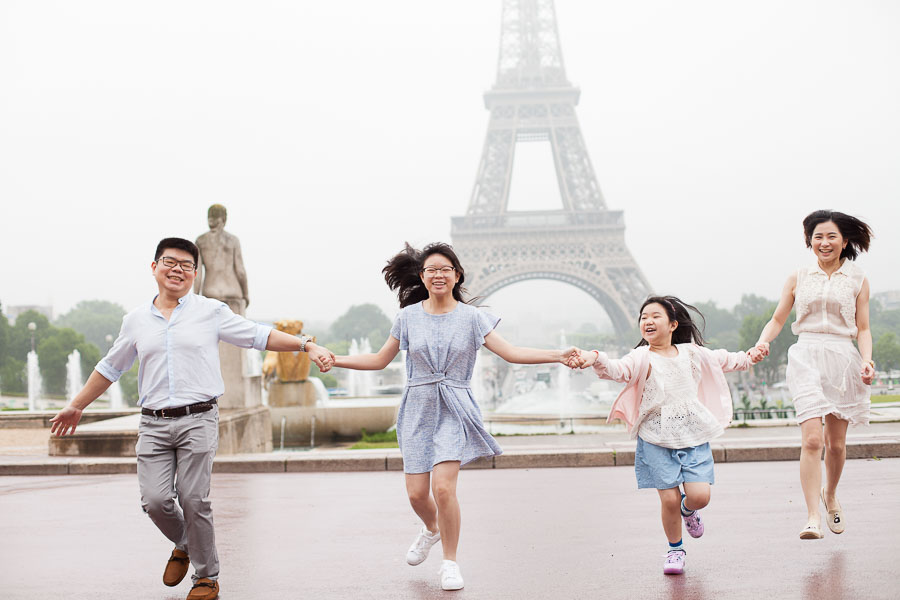 Family holding their hands for a family portrait session at Trocadero, Eiffel Tower in Paris