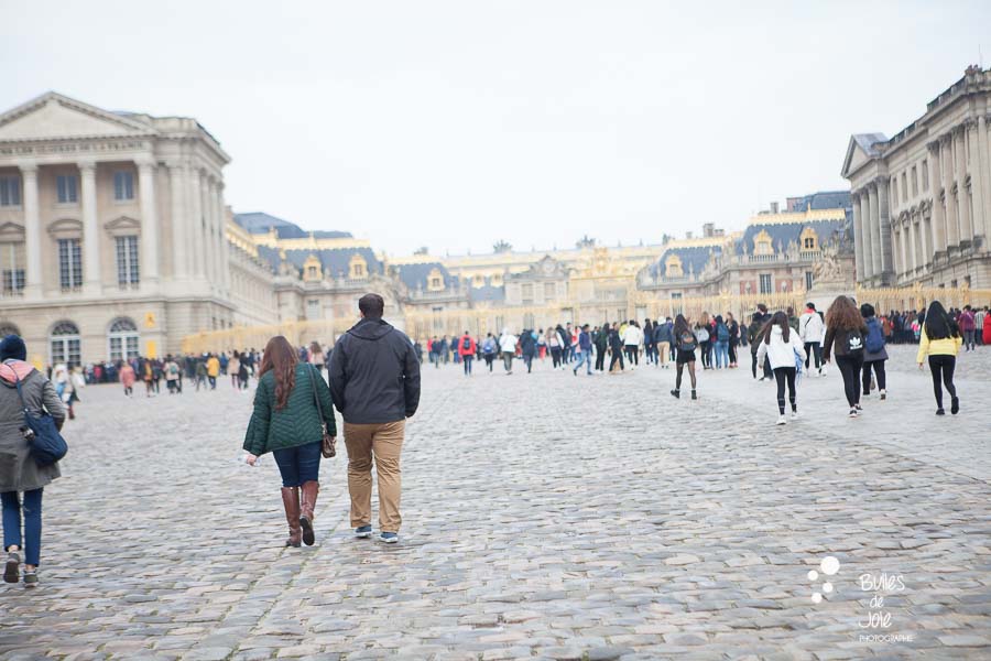 Candid shot of a couple walki,g before the suprise proposal - Versailles 